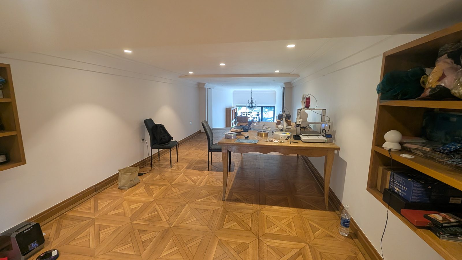 L'atelier — Après, depuis le même angle : la table de repas devenue établi, les tissus en attente sur l'étagère