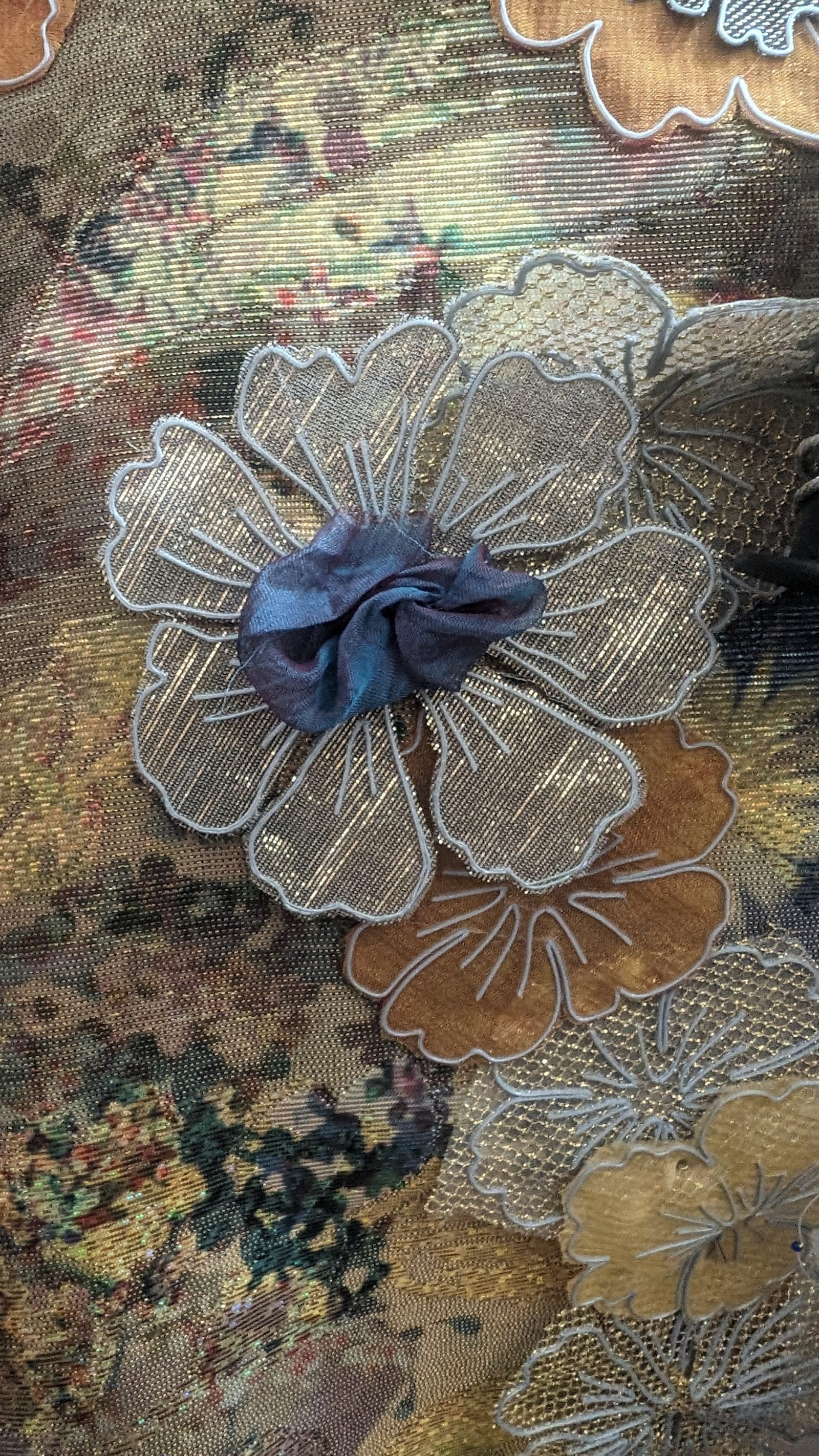 Re-former le textile — Une fleur seule — pétales de lamé découpés au ras de la ligne, cœur de soie froissée